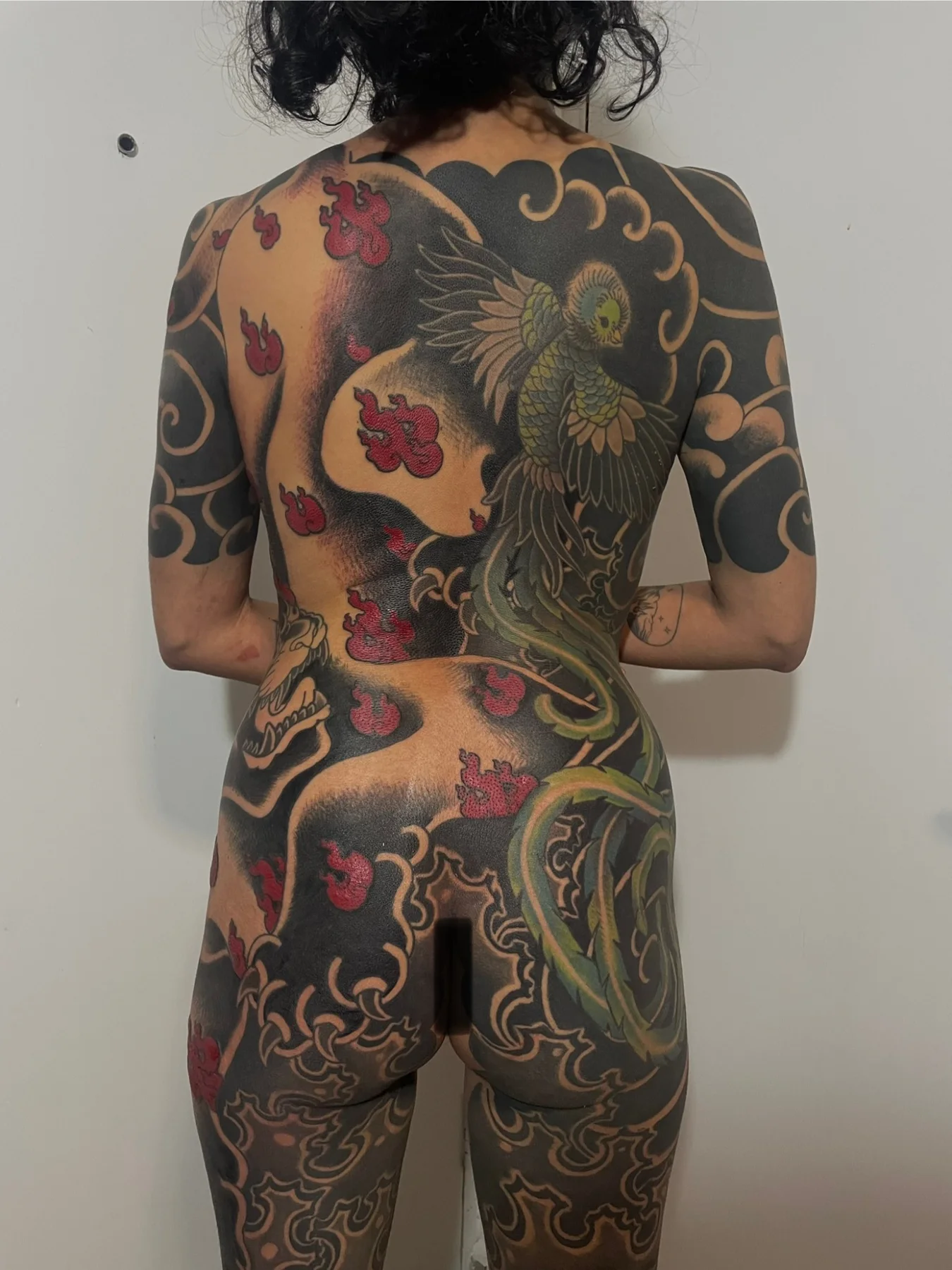 Large-scale full back tattoo with blackwork and colour